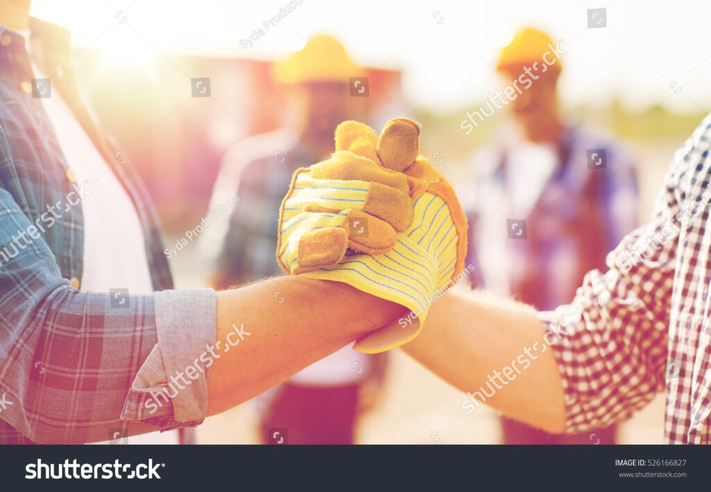 building teamwork; partnership gesture; people; close-up builders; hands in gloves